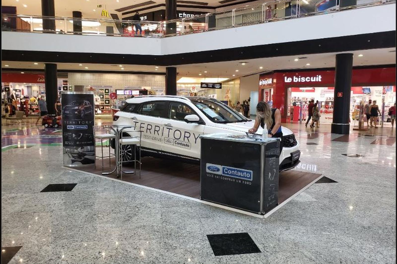 Tablado com carpete, carro e balcão para test-drive